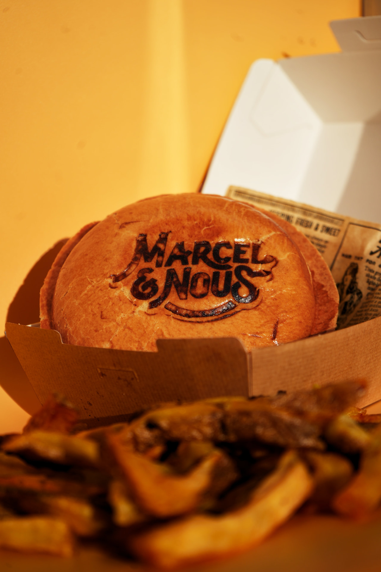Scellé Marcel et Nous marqué sur son bun, accompagné de frites